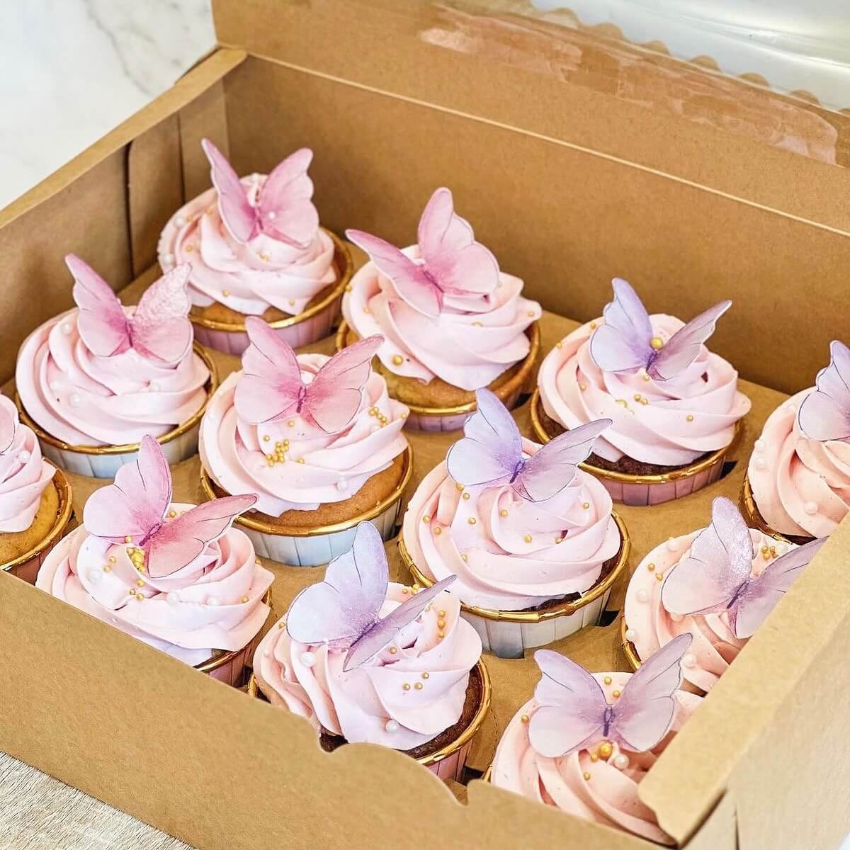 Box of cupcakes with pink frosting and butterfly decorations - cupcakes Sydney