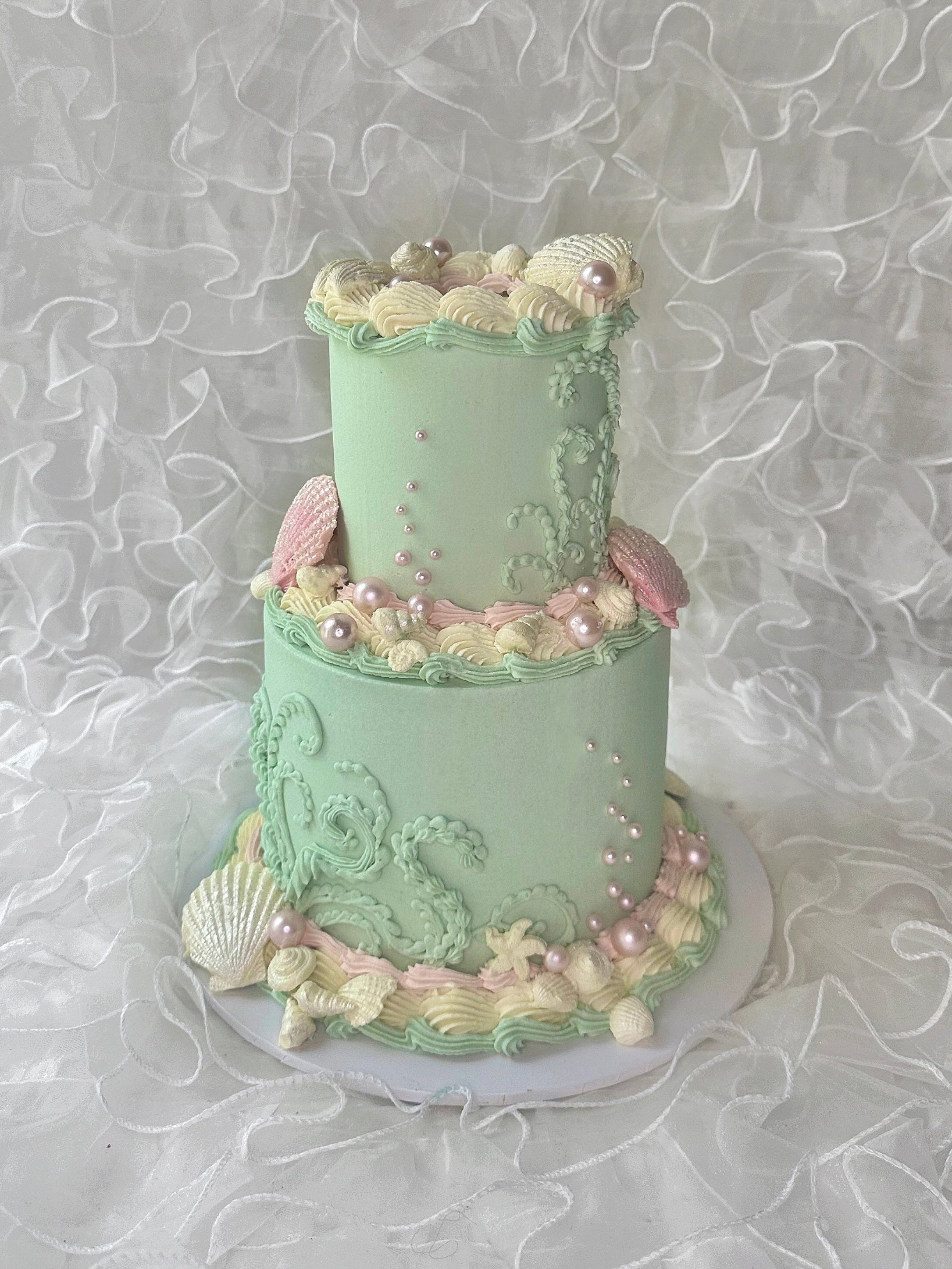 Turquoise ocean themed cake with pearls and shells detailing