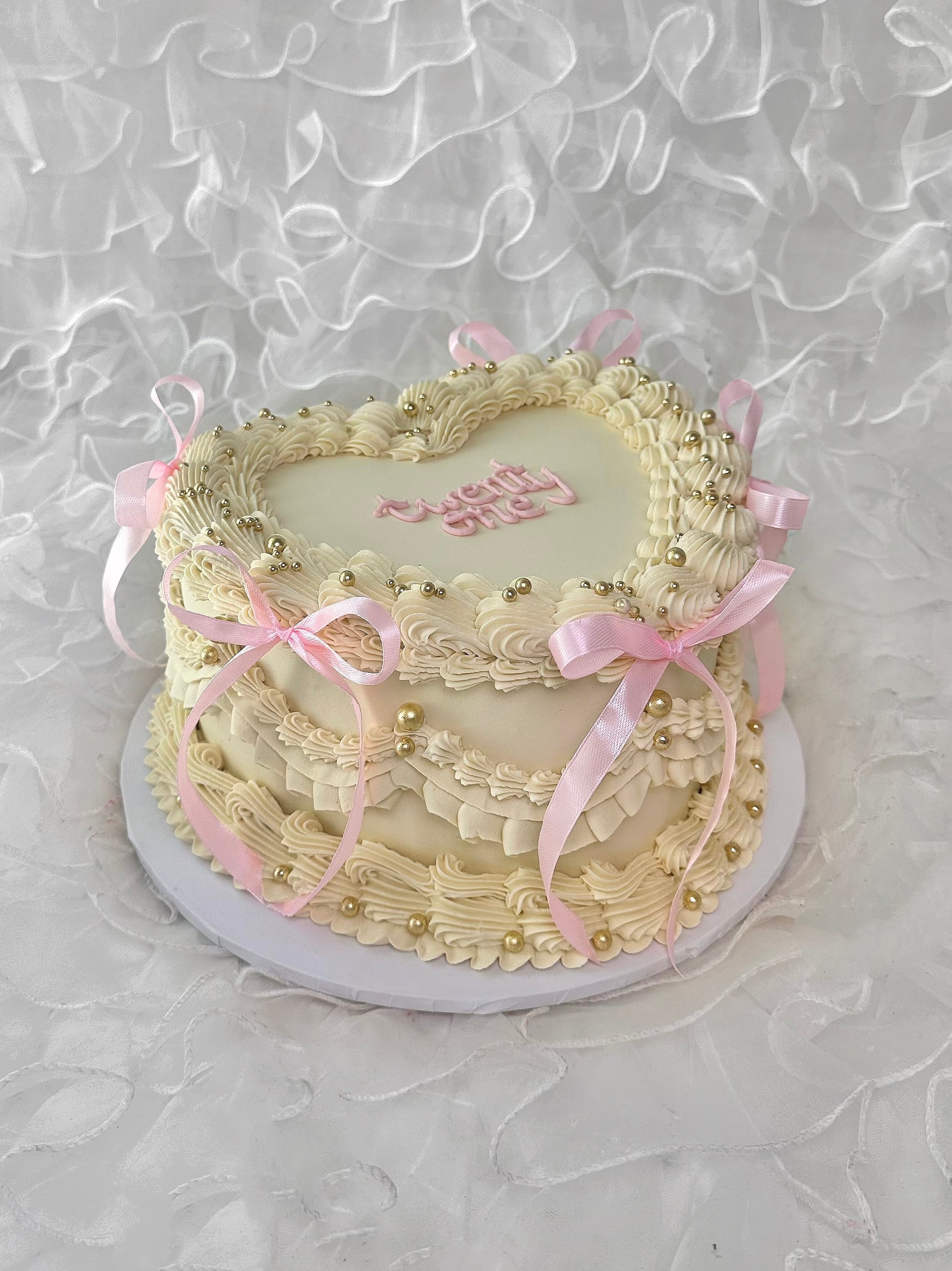 Decorative cake with pink ribbons and gold pearls