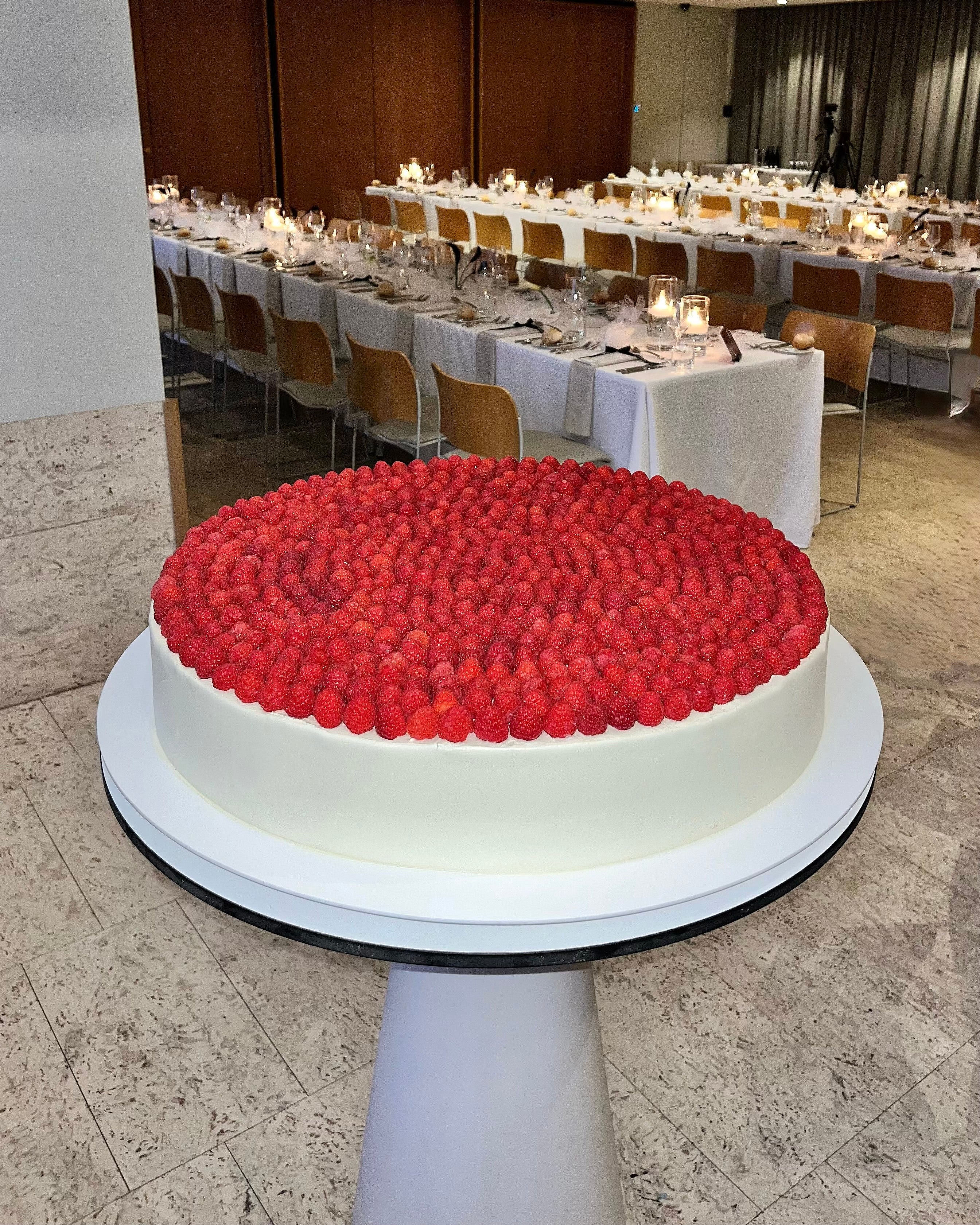 Large round cake with raspberry's on top 