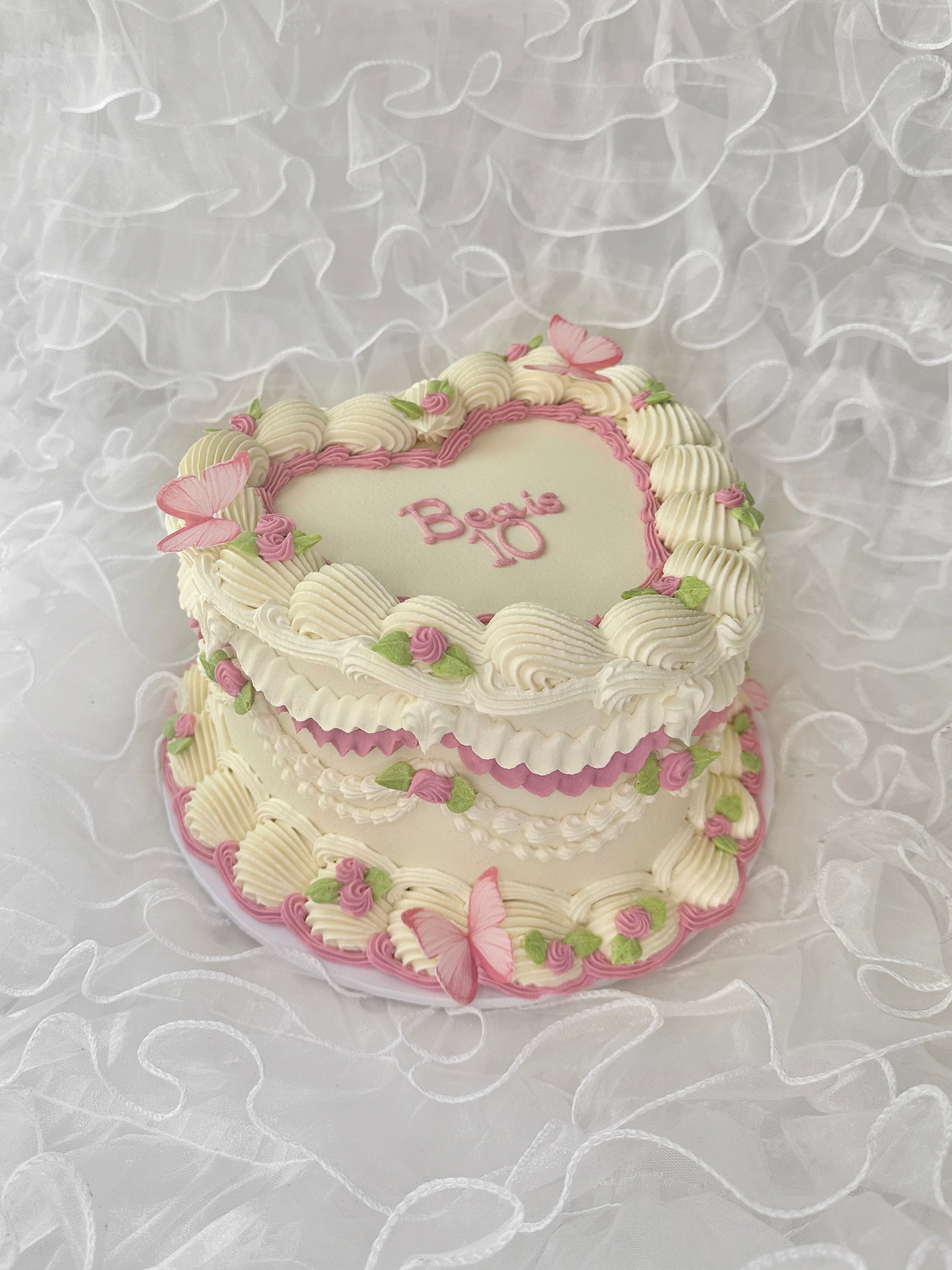 White cake with pink floral and butterfly detailing 