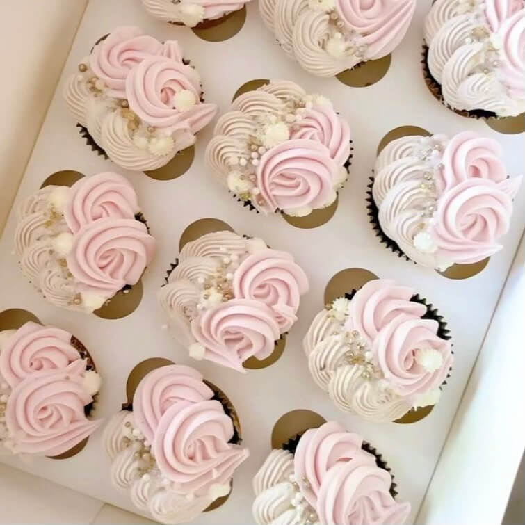 Cupcakes with pink and white frosting in a box