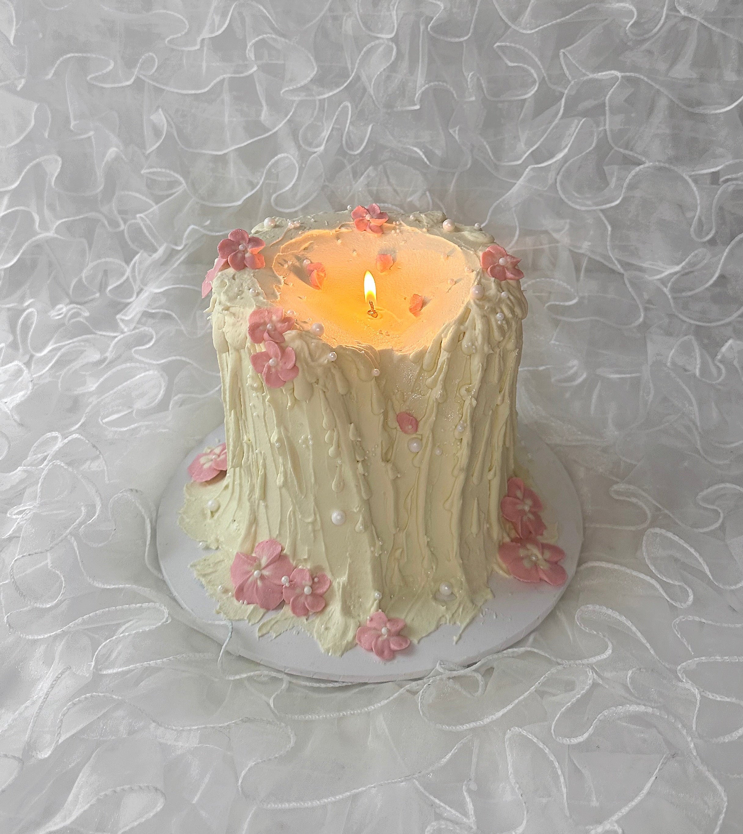 Melting candle cake with pink flower detailing 