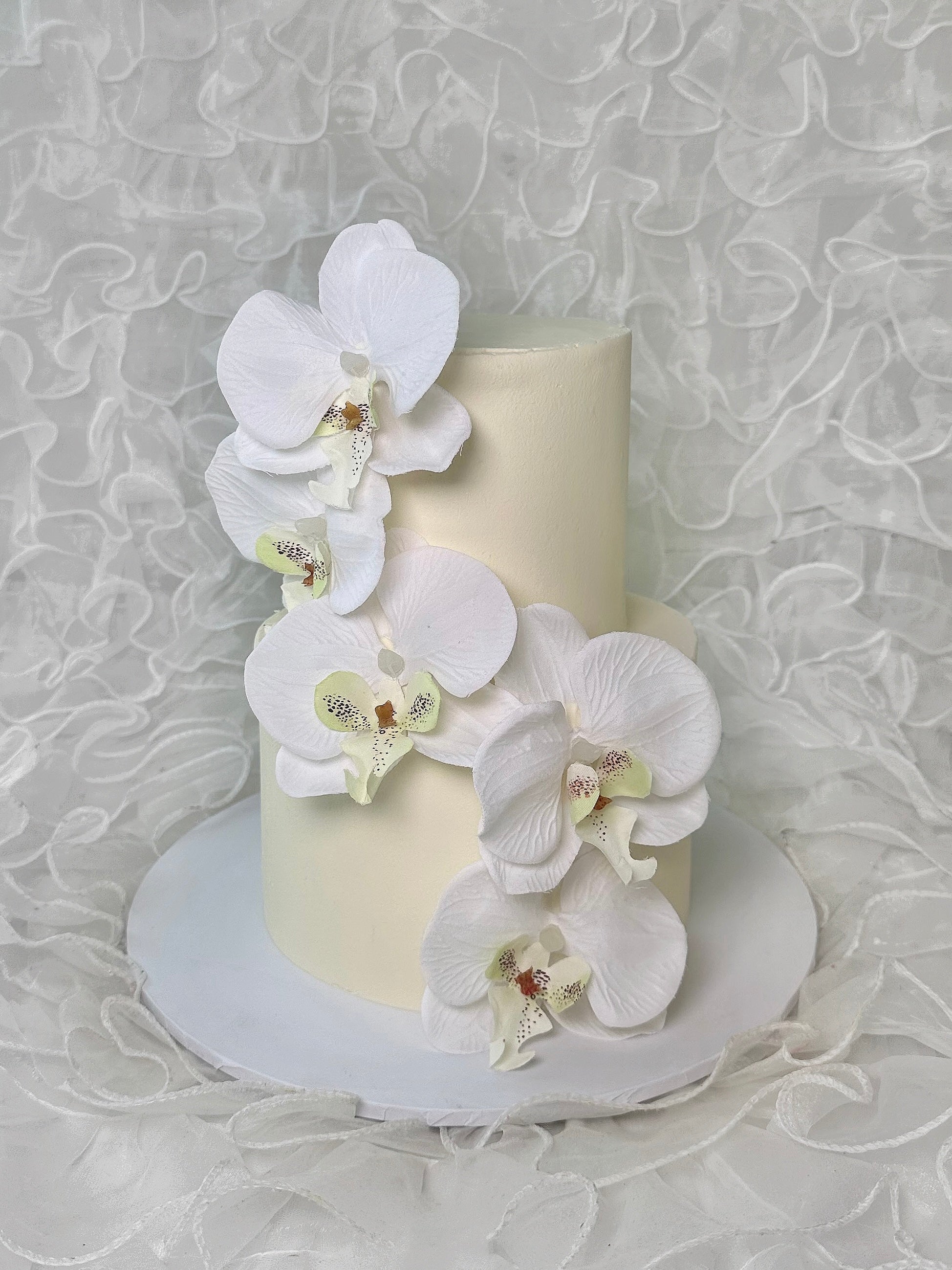 Two-tiered luxury cake with white orchids